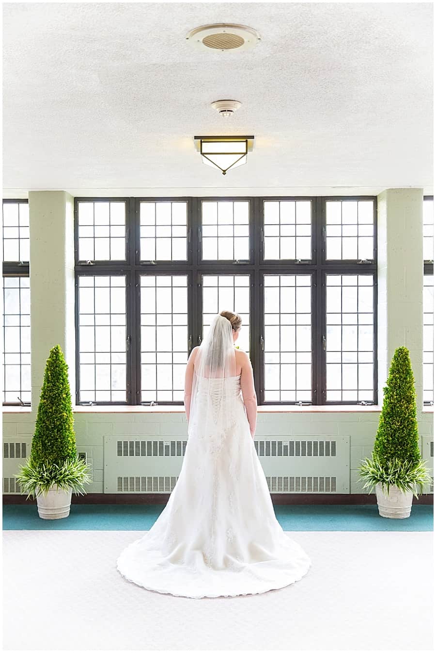 Bride in front of stained glass windows before wedding