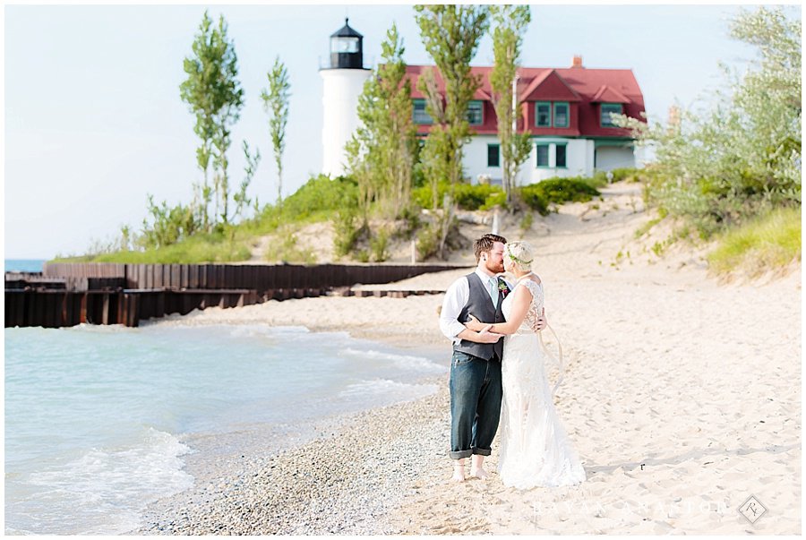 Bride and Groom walking lake michigan shoreline at point bestie lighthouse