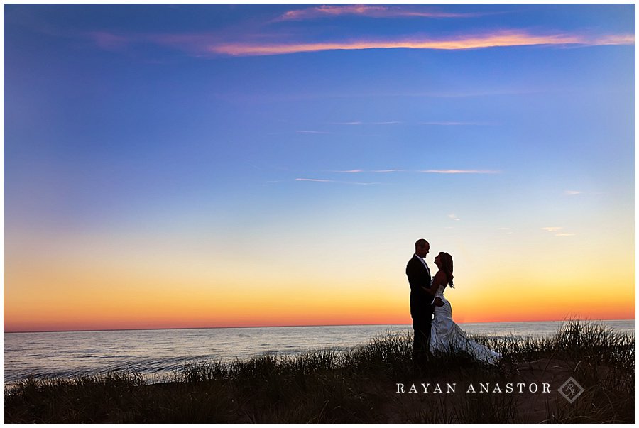Bride and groom at sunset overlooking lake michigan