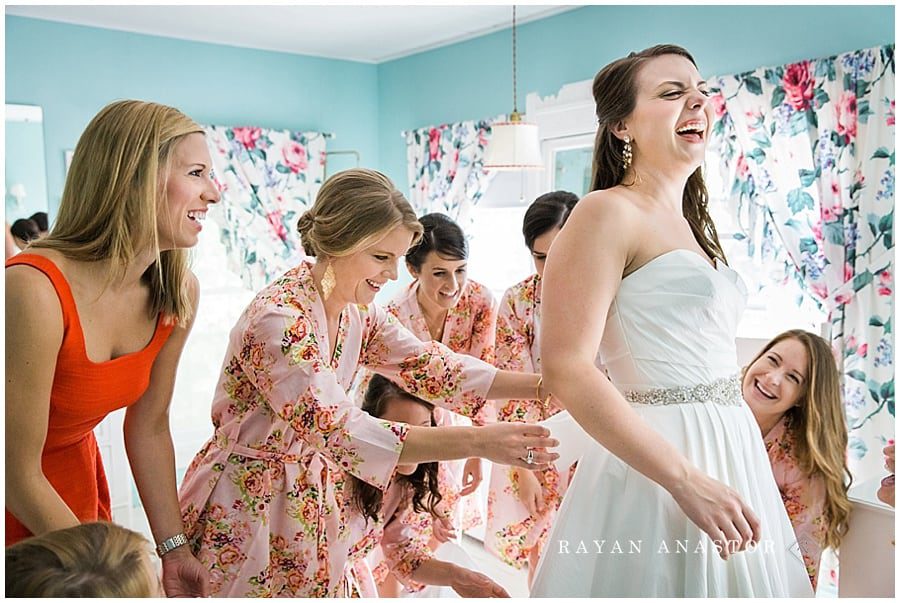 bride having fun with the girls getting dressed