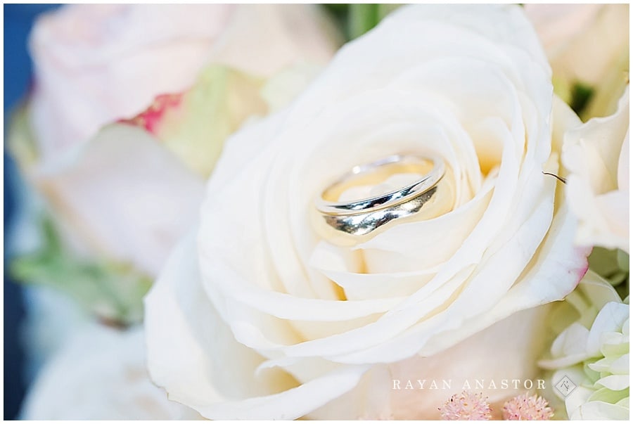 wedding rings in flowers from smitten events