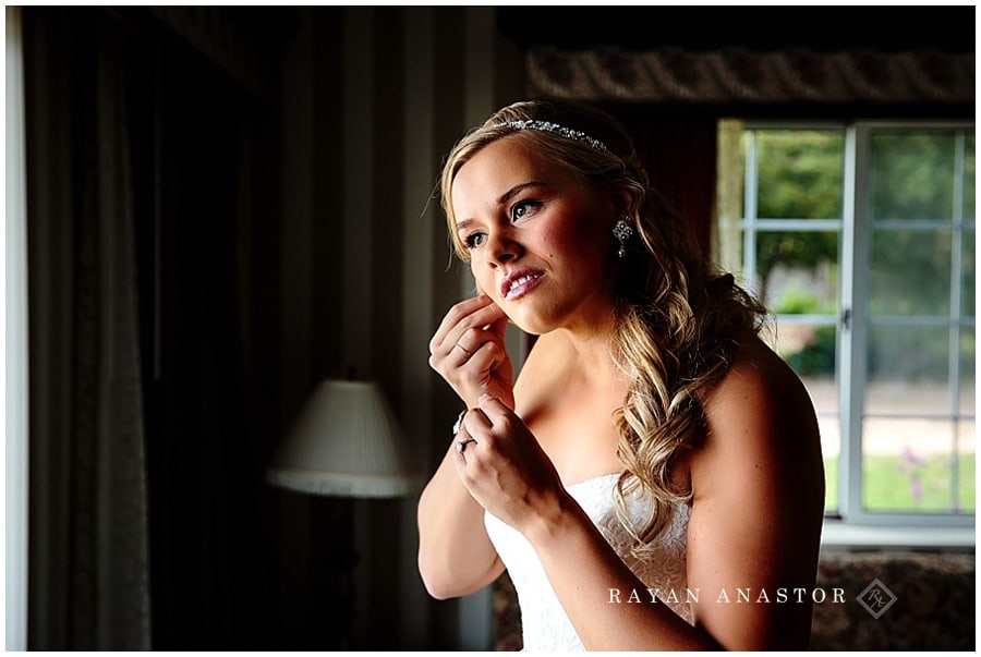 bride putting earrings on