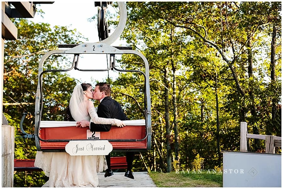 bride and groom riding ski chair lift off the mountain top at the homestead resort