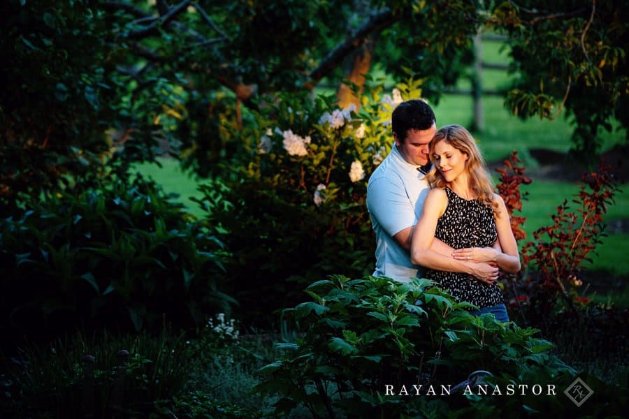 engagement photos in garden with lilacs at sunset