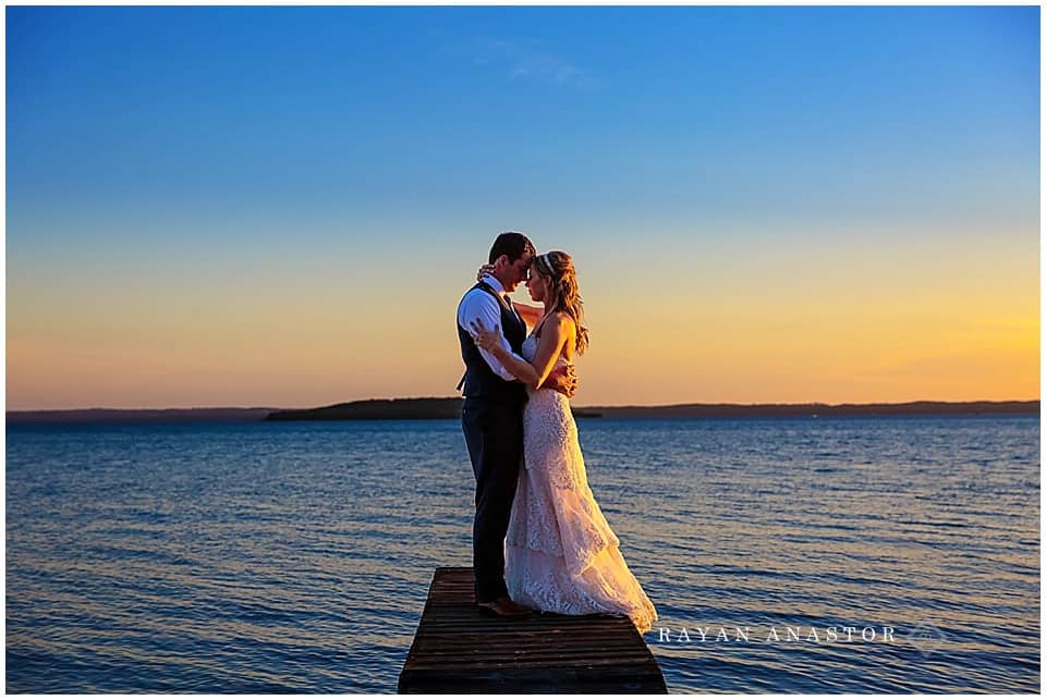 bride and groom on dock overlooking grand traverse bay