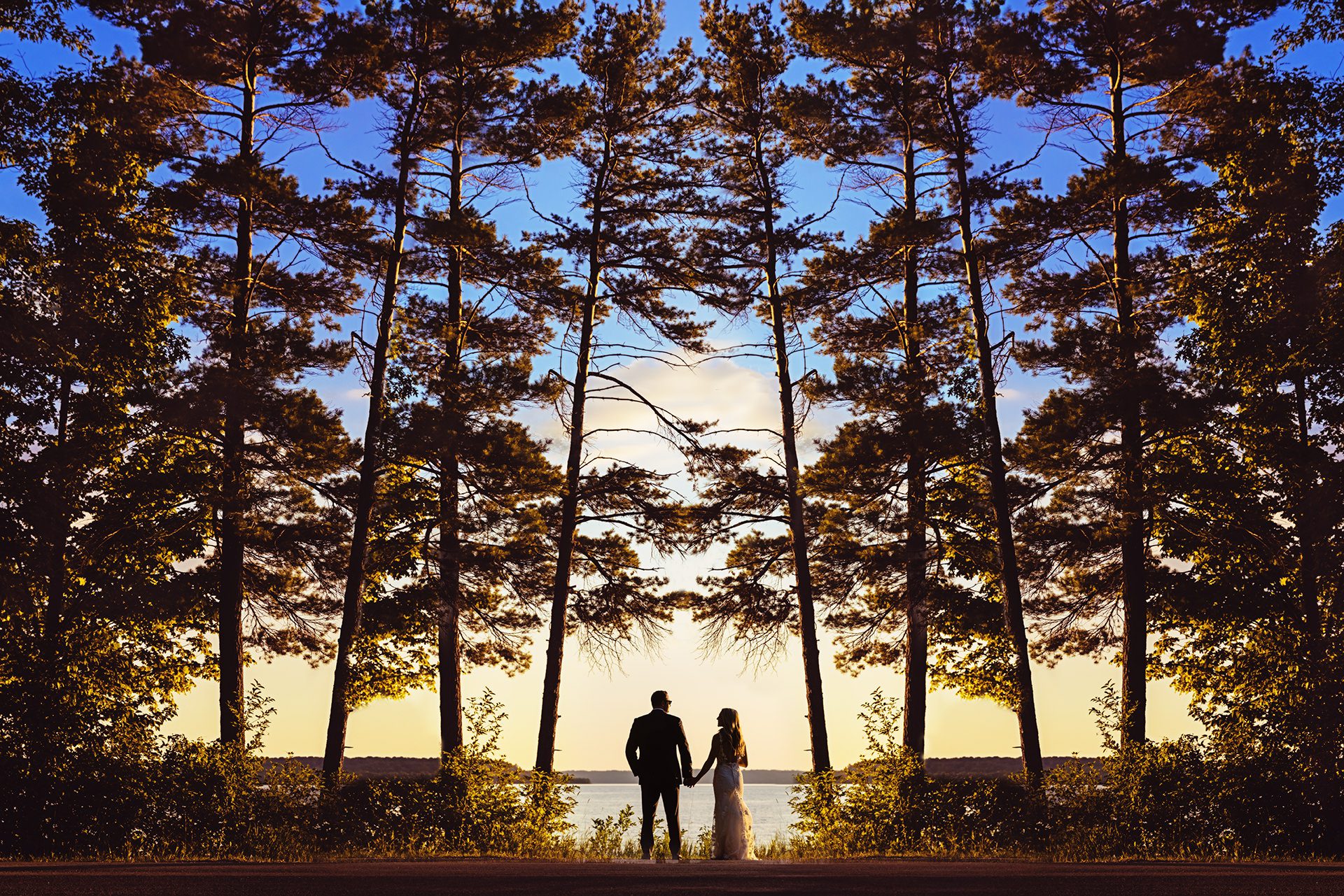 Bride and groom at sunset on Lake Michigan with trees