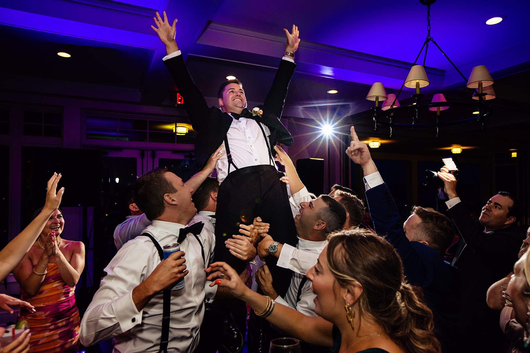 Groom being raised up during wedding reception