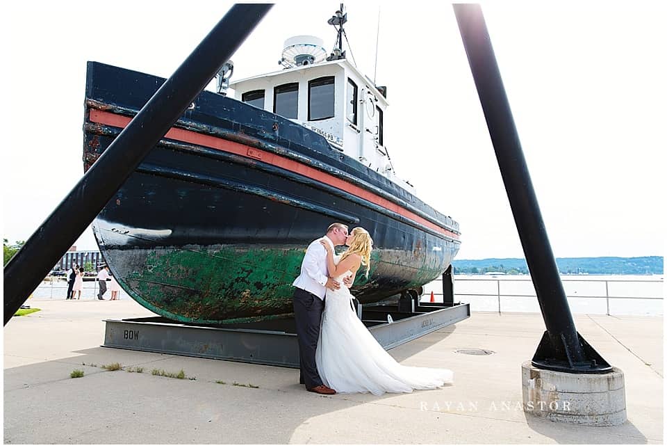 bride and groom on grand traverse bay with a boat