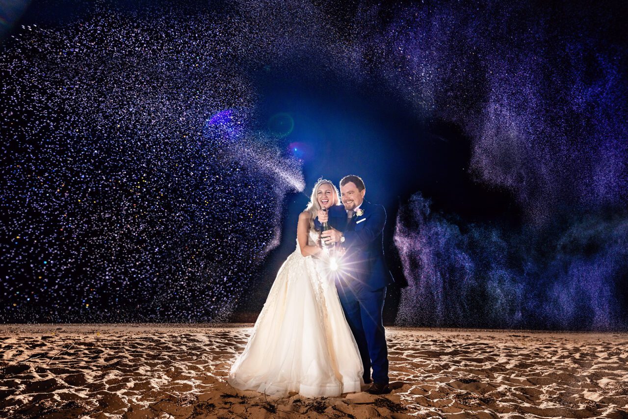 Bride and Groom spraying champaign bottle at wedding Peninsula Room