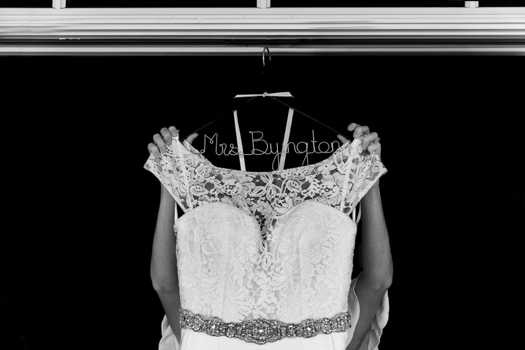 Bride taking dress off hanger before dressing