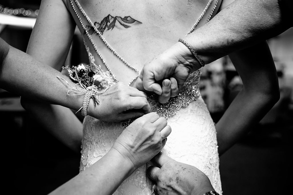 Bride Getting dress buttoned with both mothers