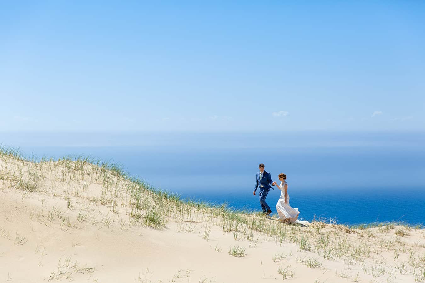 bride and groom walking through sleeping bear dunes