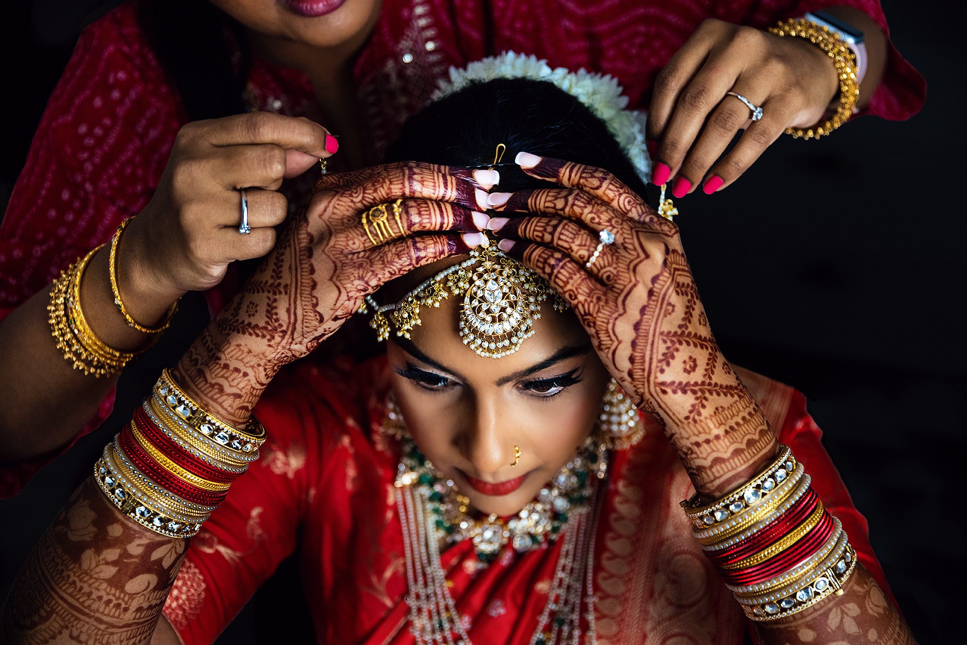 bride putting on her bindi for hindu wedding in Farmington Hills