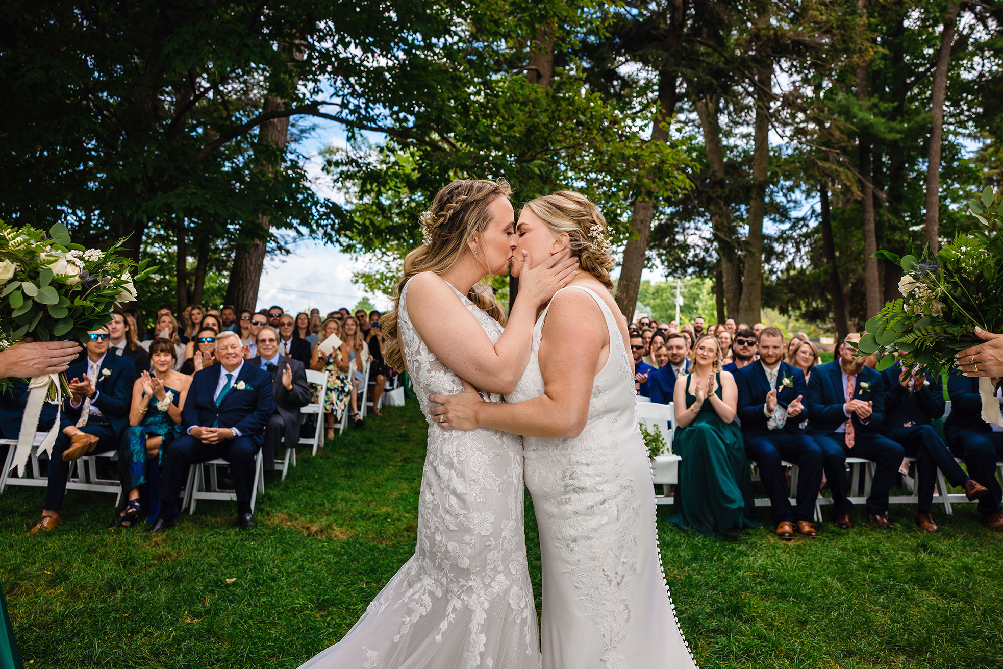 Lesbian Couple during wedding ceremony with family behind them