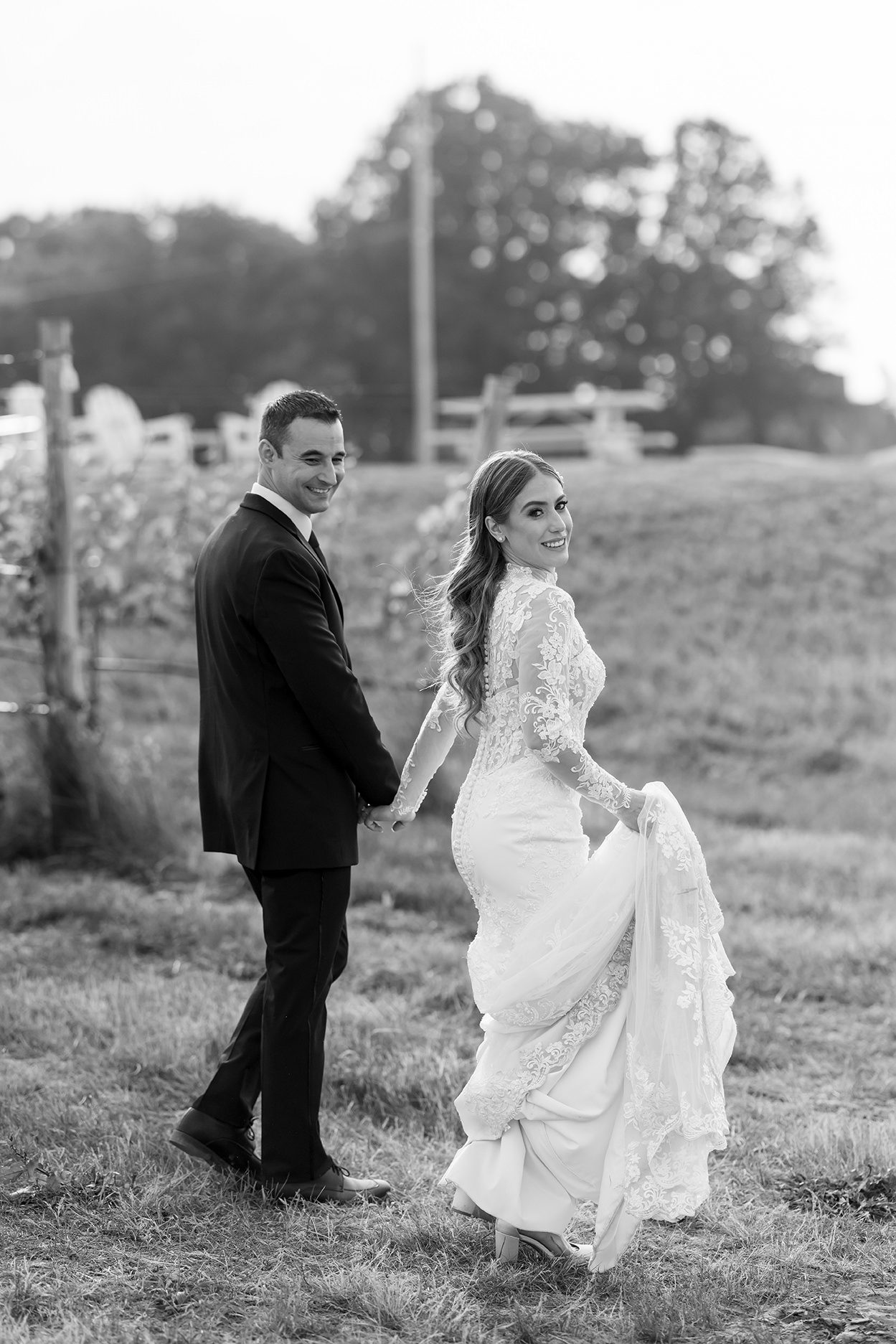 bride and groom walking through the vineyard at Mari Vineyards