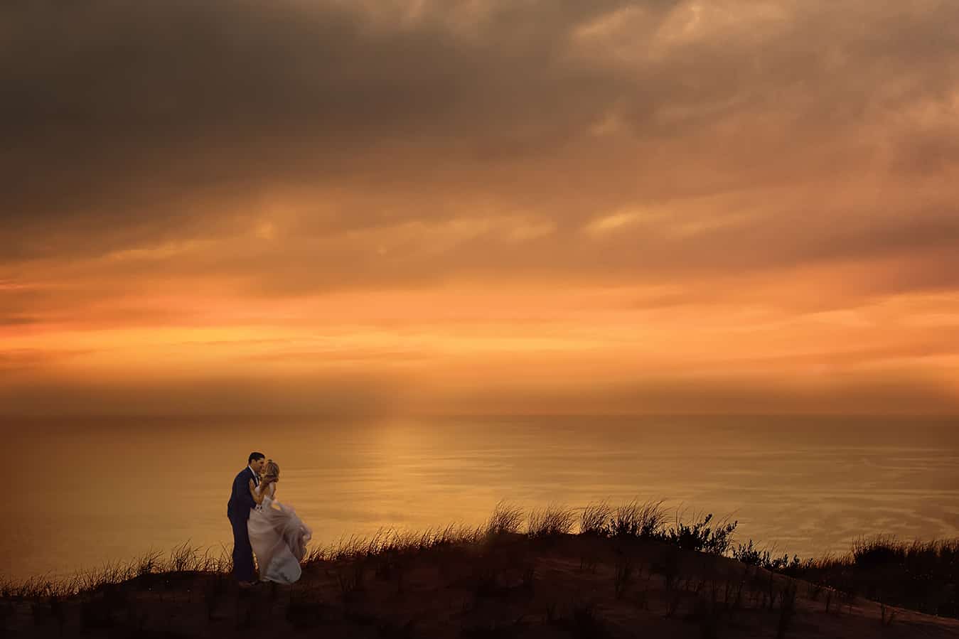bride and groom at sunset in sleeping bear dunes on Lake Michigan