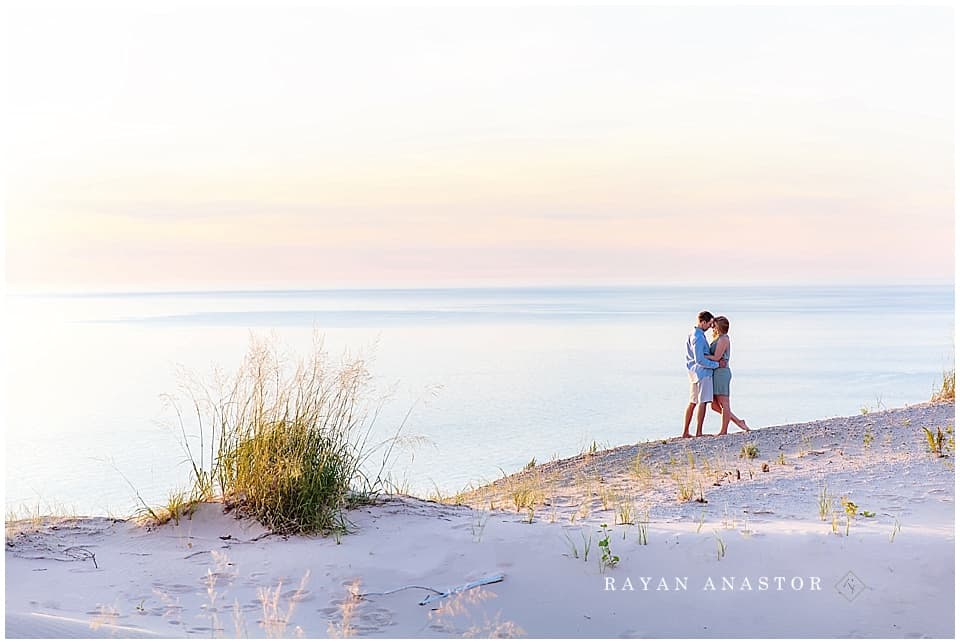 Engagement photo of couple at sunset on Lake Michigan in sand dunes