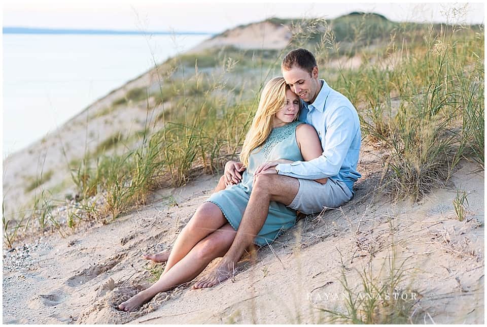 Engagement photo of couple at sunset on Lake Michigan in sand dunes