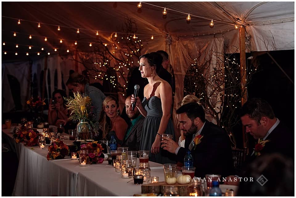 wedding reception with string lights and candles in tent on private residence