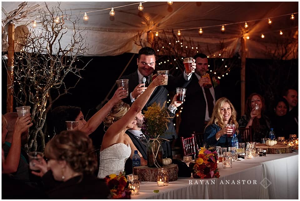 wedding reception with string lights and candles in tent on private residence