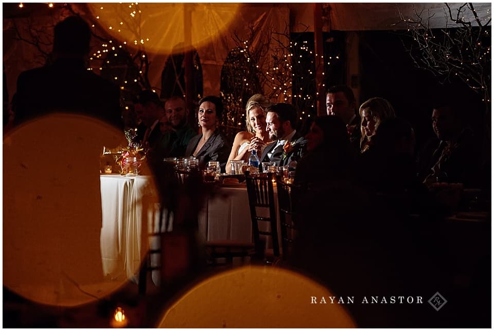 wedding reception with string lights and candles in tent on private residence