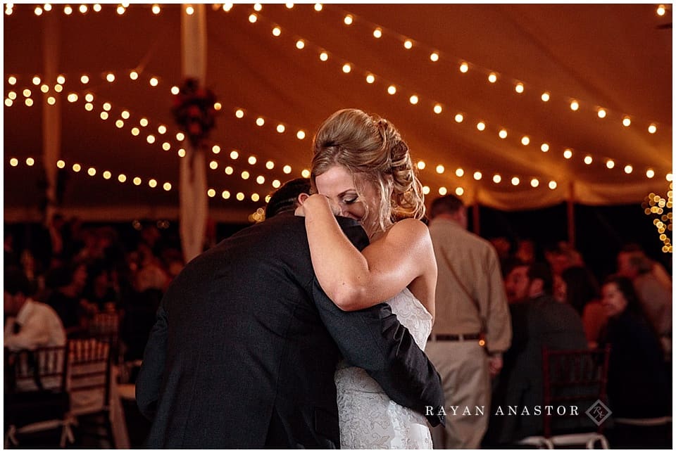 wedding reception with string lights and candles in tent on private residence