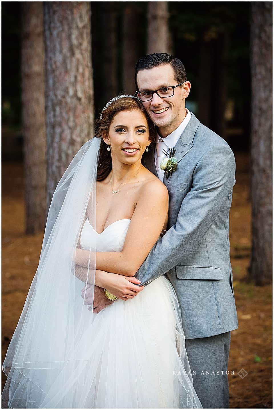 bride and groom among tall pine trees