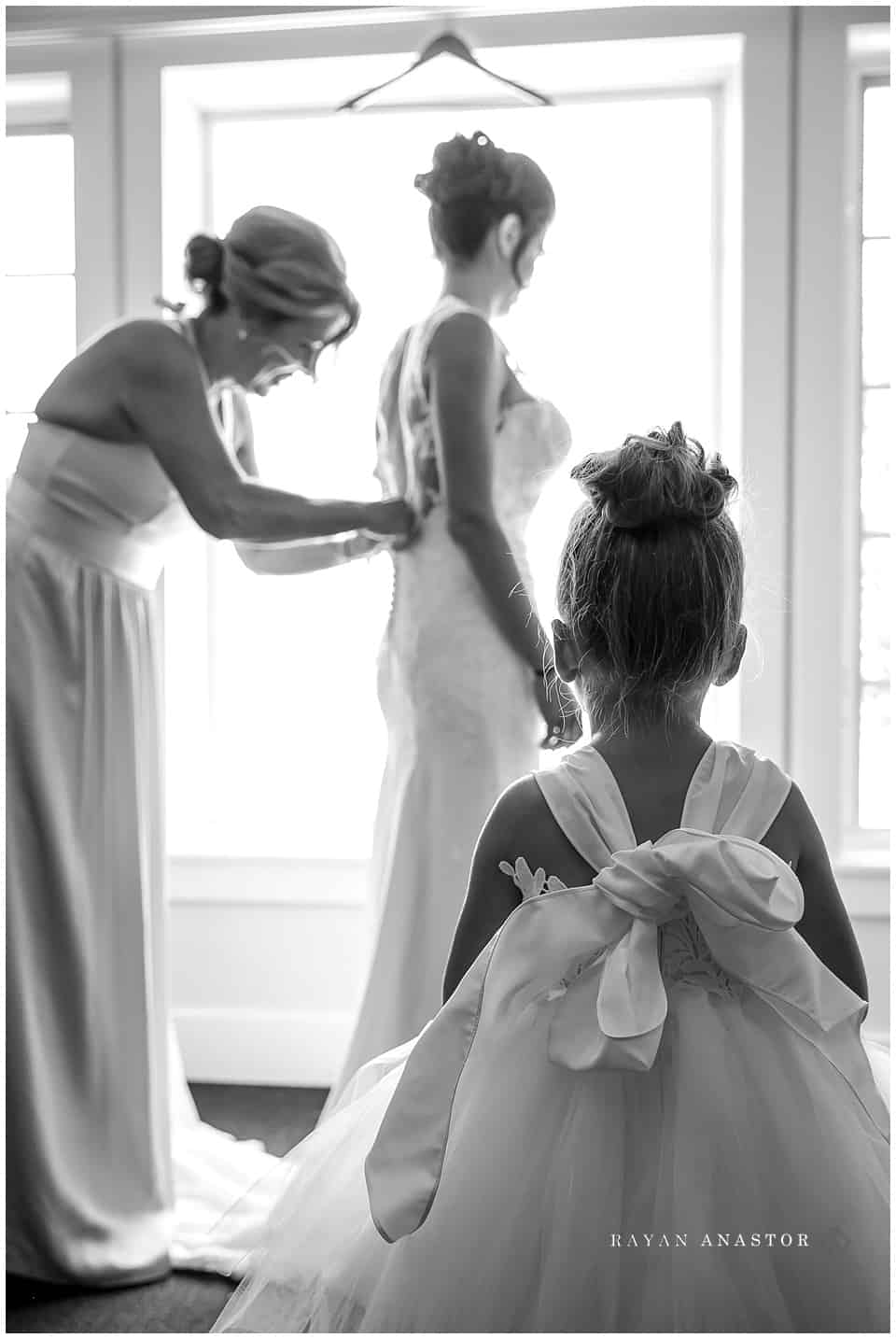 flower girl watching bride get dress