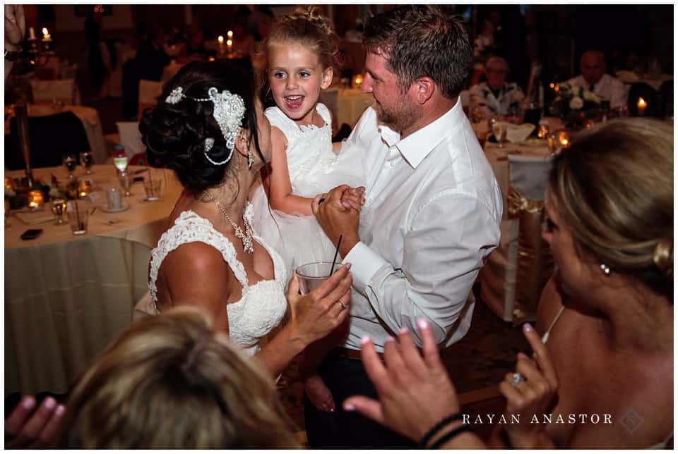 bride and groom with their daughter dancing