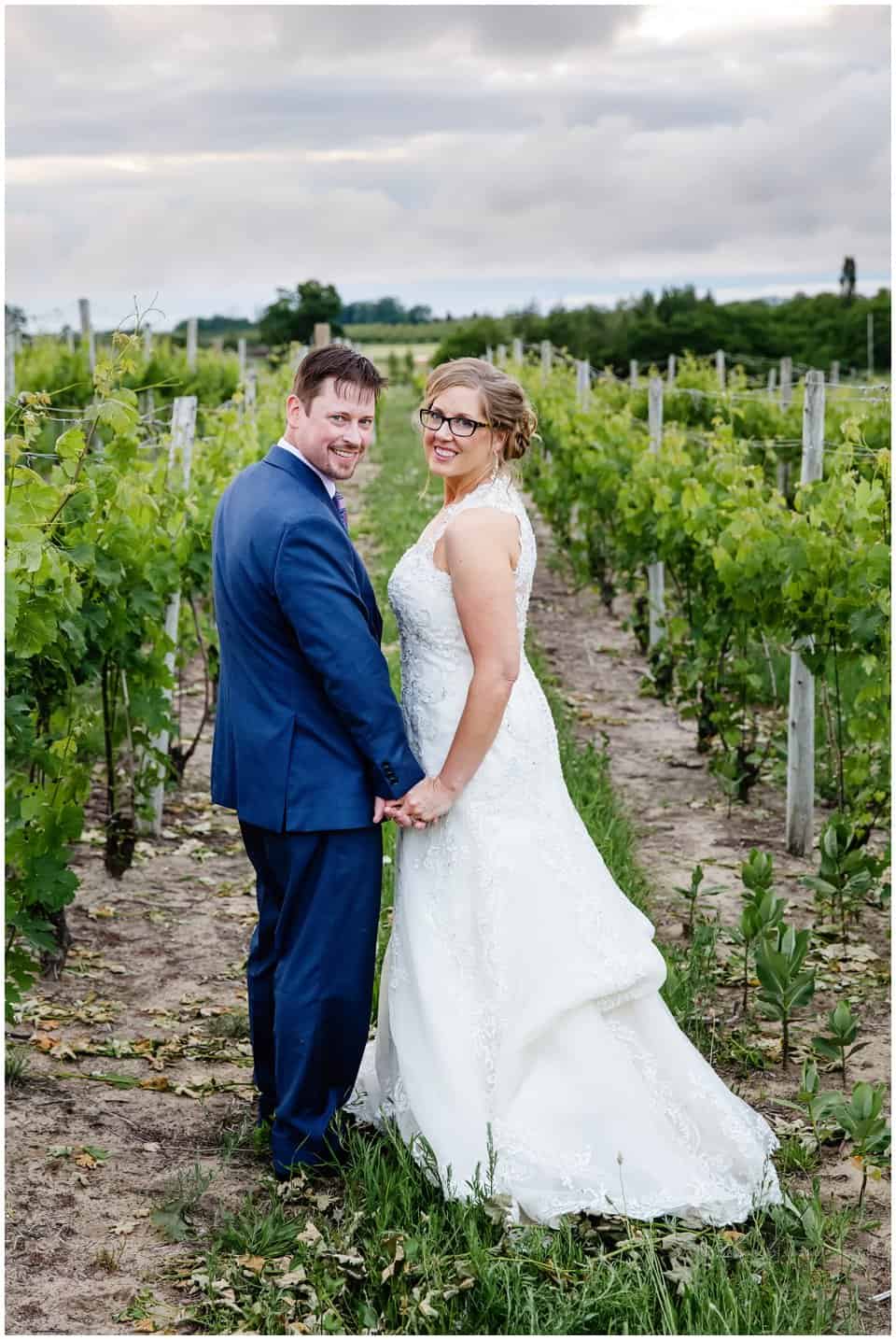 bride and groom in aurora cellars vineyard