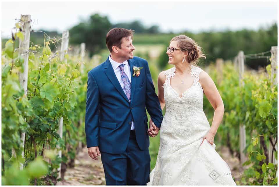 Bride and Groom walking through vineyard
