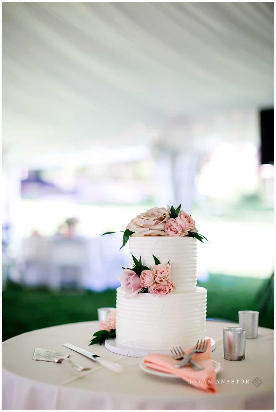 simple white wedding cake with pink flowers