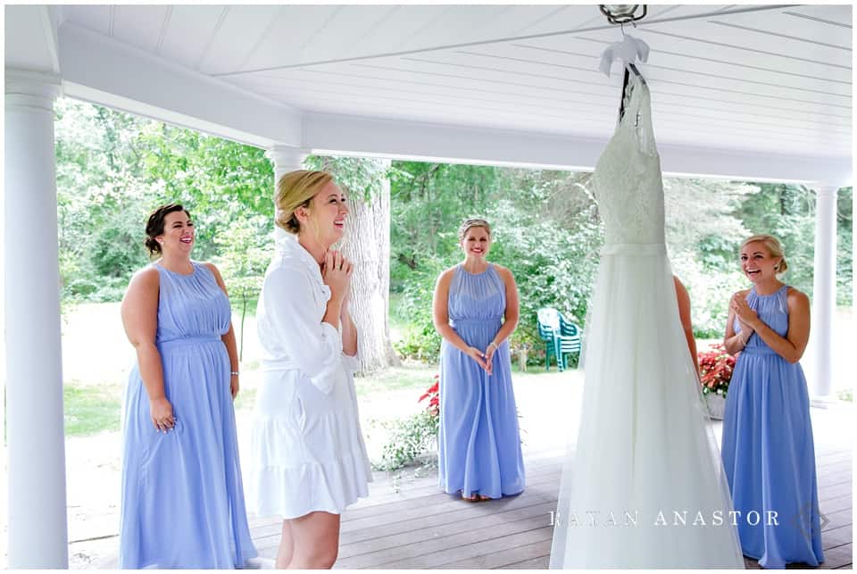 bride getting dressed with very emotional bridal party