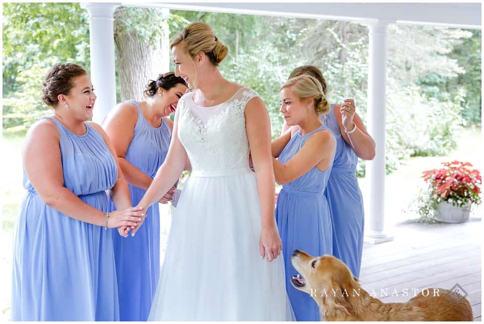 bride getting dressed with very emotional bridal party