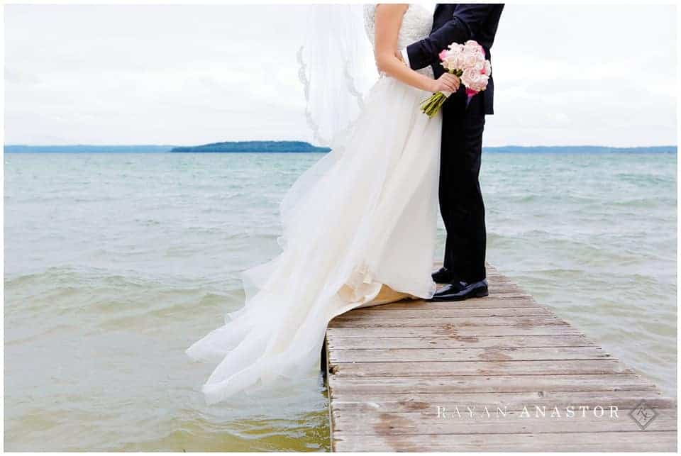 bride and groom on dock over water