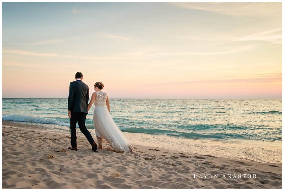 bride and groom taking a walk on lake michigan