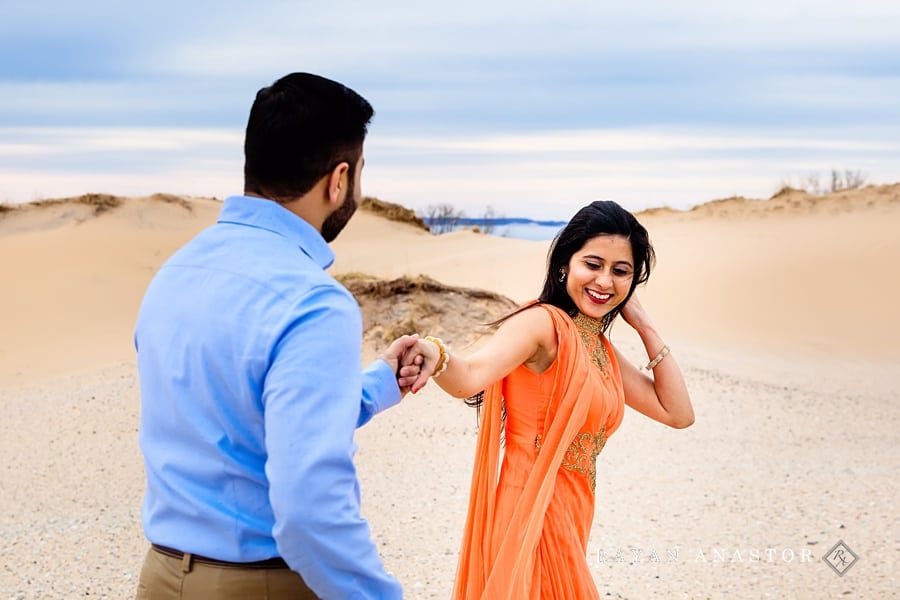 couple having fun walking through sand dunes