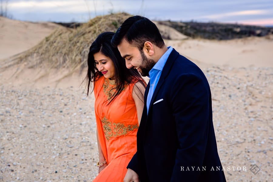 couple wandering through sand dunes for engagement photos