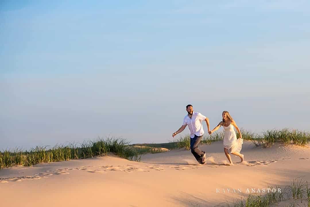 Bride and Groom Running through sand dunes