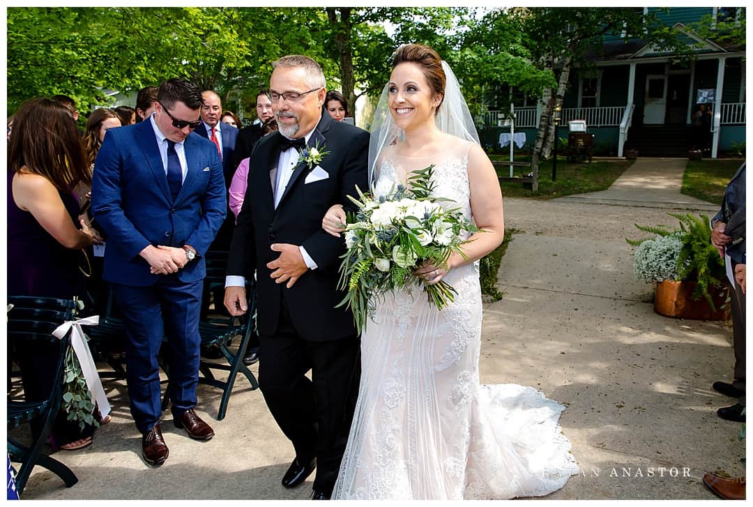 bride walking to her groom with her father