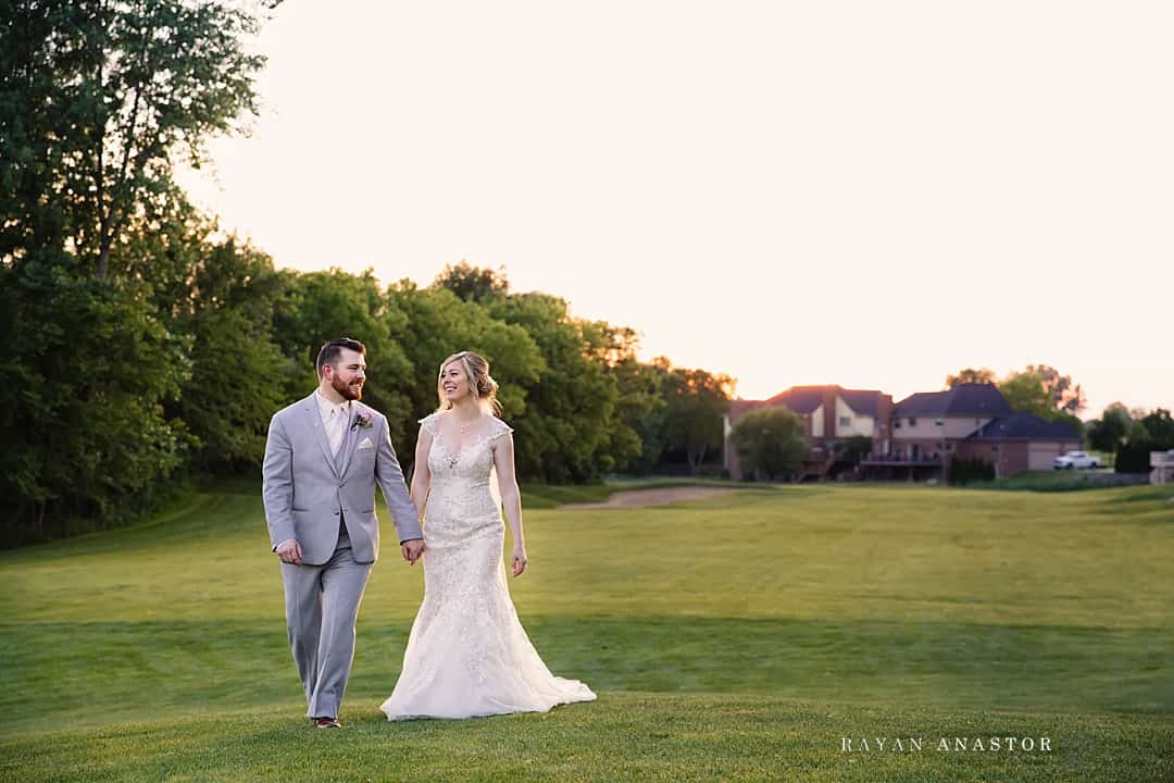 bride and groom at sunset on golf course