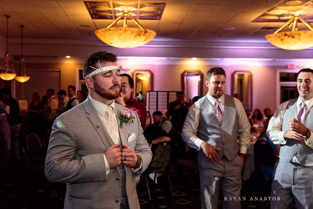 groom wearing garter on head