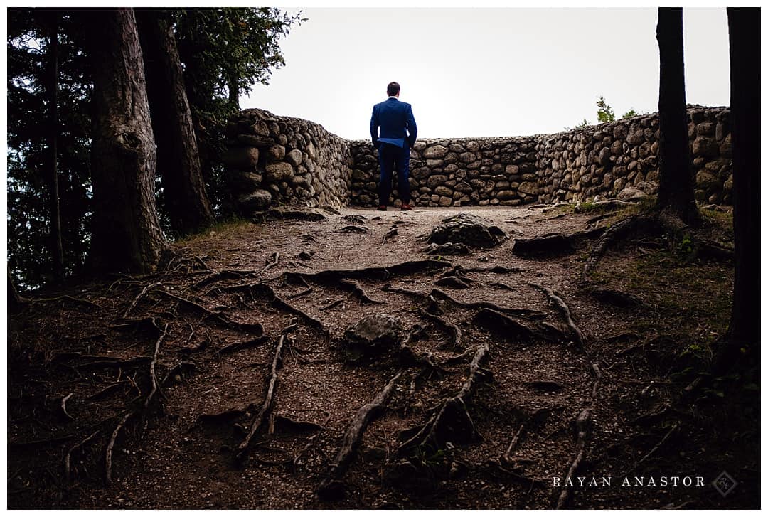 groom awaiting first look at sunset rock