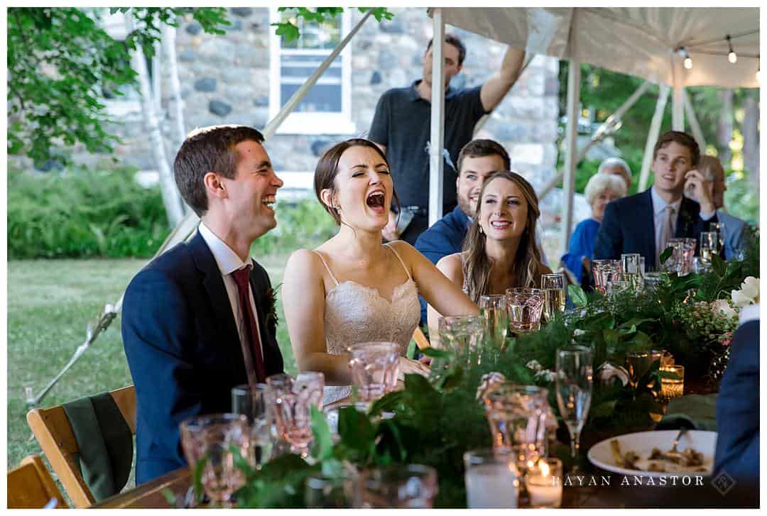 bride and groom laughing during toasts