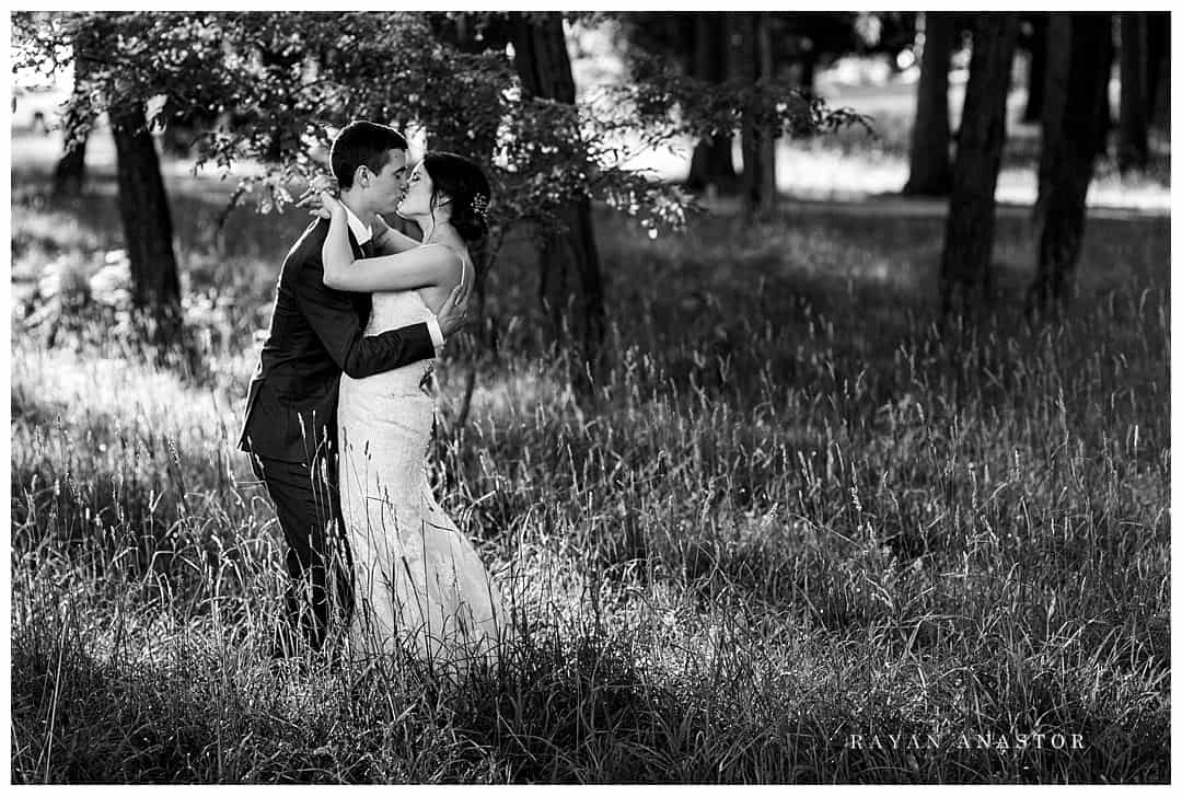 bride and groom in tall grass at sunset