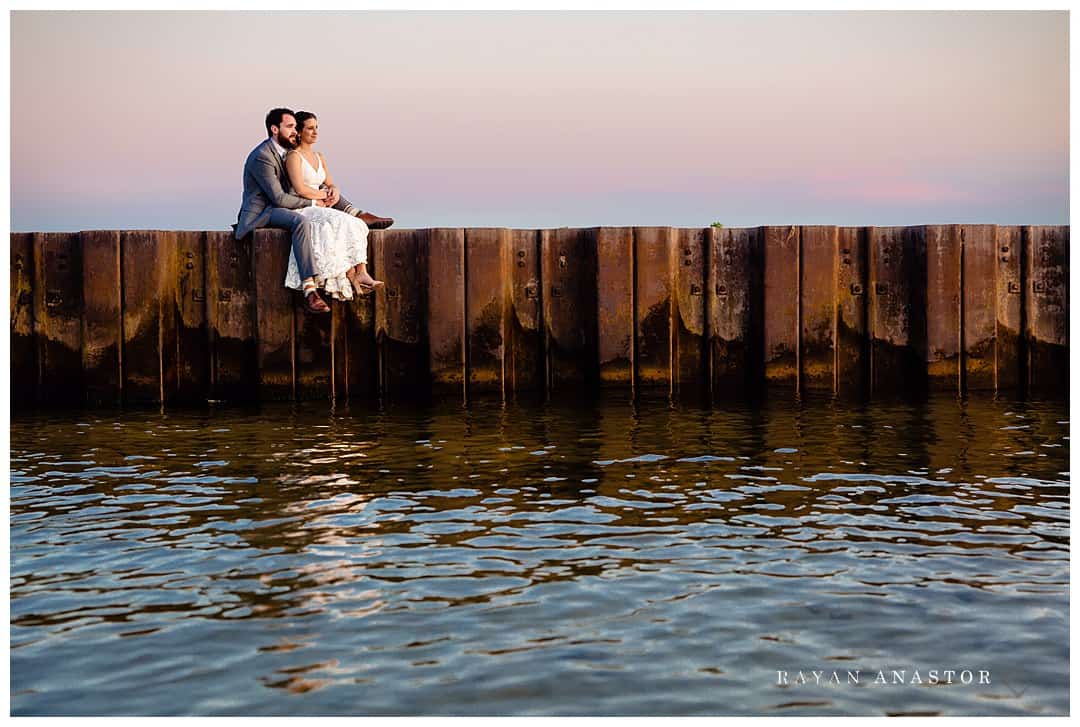 bride and groom on Lake Michigan pier at sunset
