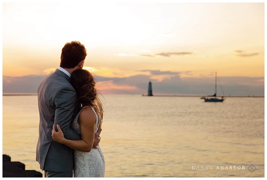bride and groom watching sunset at Frankfort lighthouse