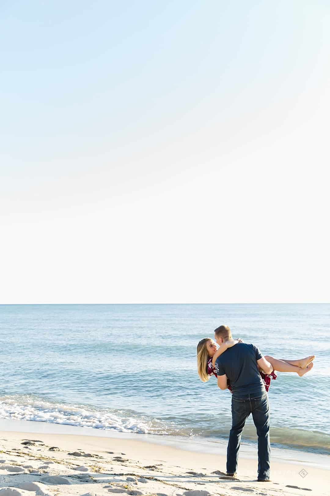 groom carrying bride to Lake Michigan