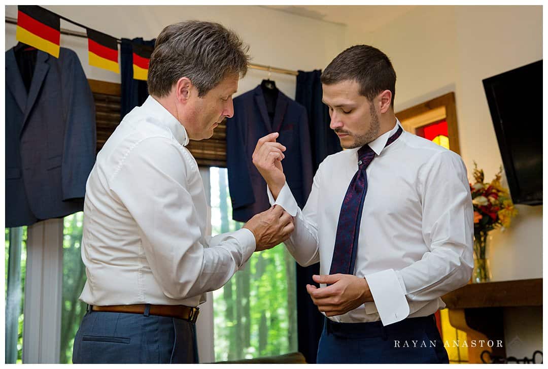 dad putting on grooms cufflinks