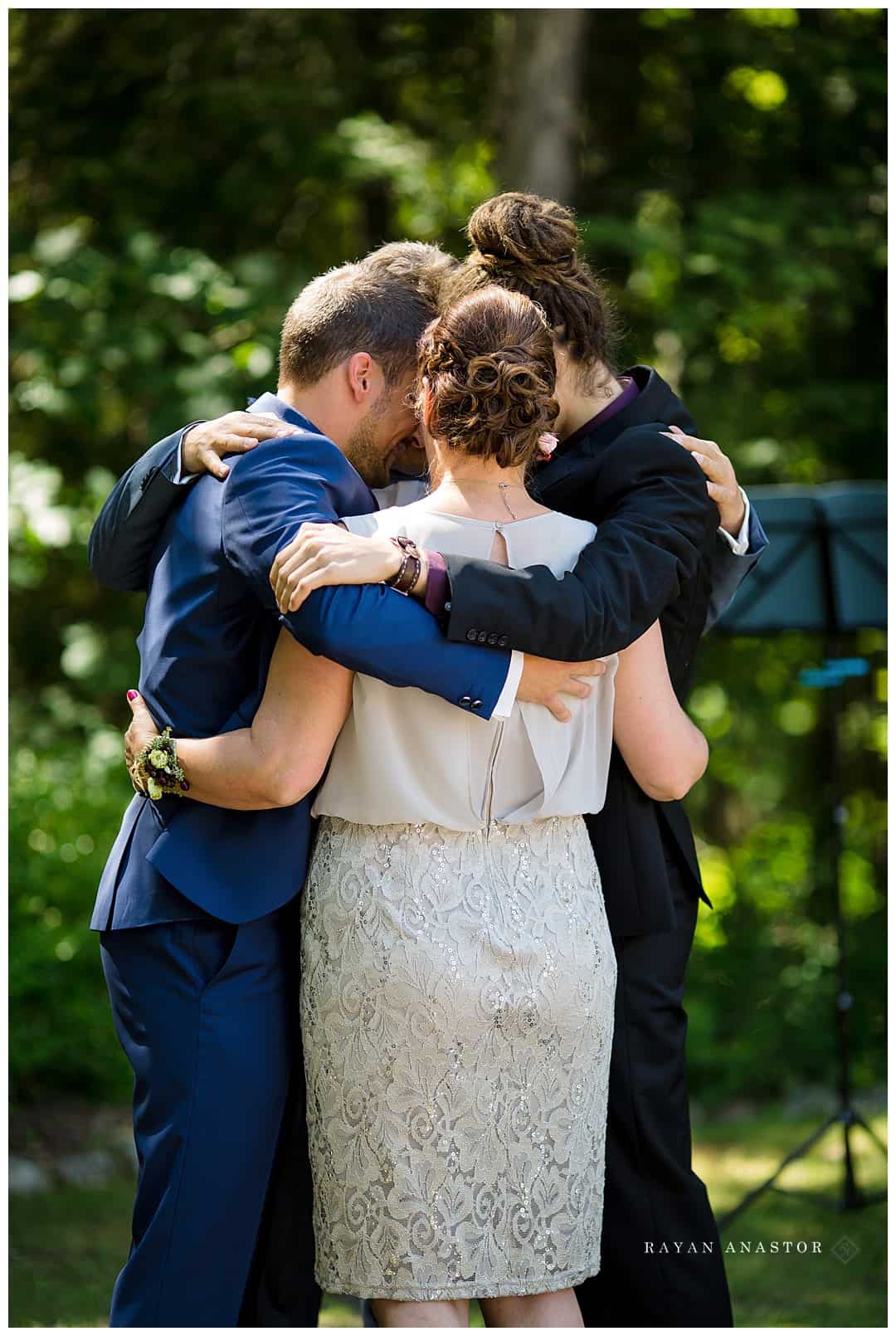 groom and family hugging before wedding